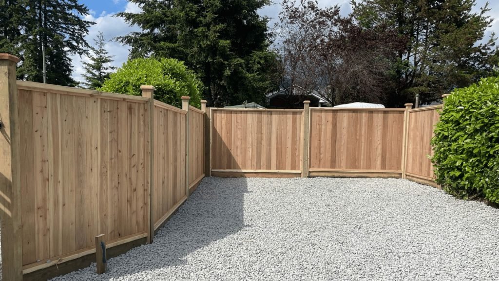 New cedar fence installed by professional fence contractors in Abbotsford enclosing a gravel yard.