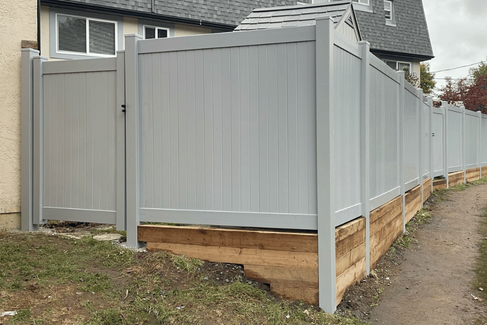 Vinyl privacy fence with retaining base installed by expert fence contractors in Abbotsford